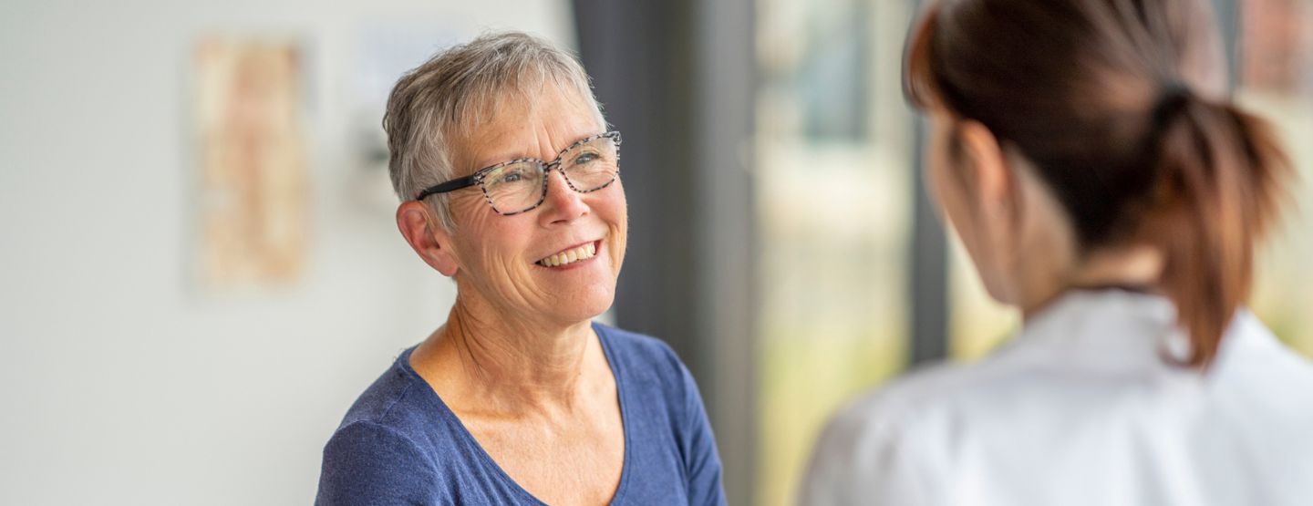 Older woman talking to member of healthcare team