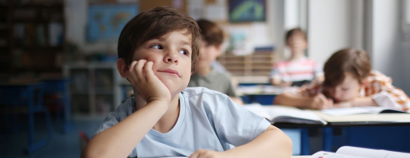 Young boy daydreaming in a classroom