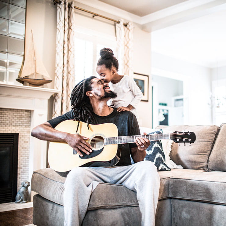 Man playing guitar with child