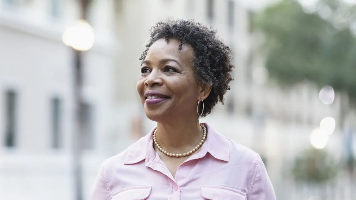 mature woman smiles outdoors