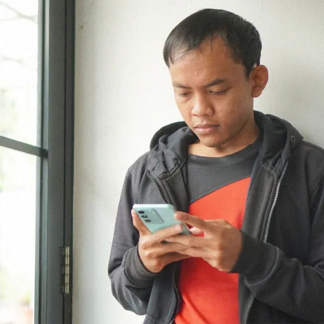 a young man uses his phone 