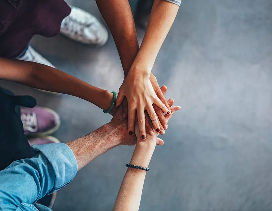 A close up of five overlapping hands