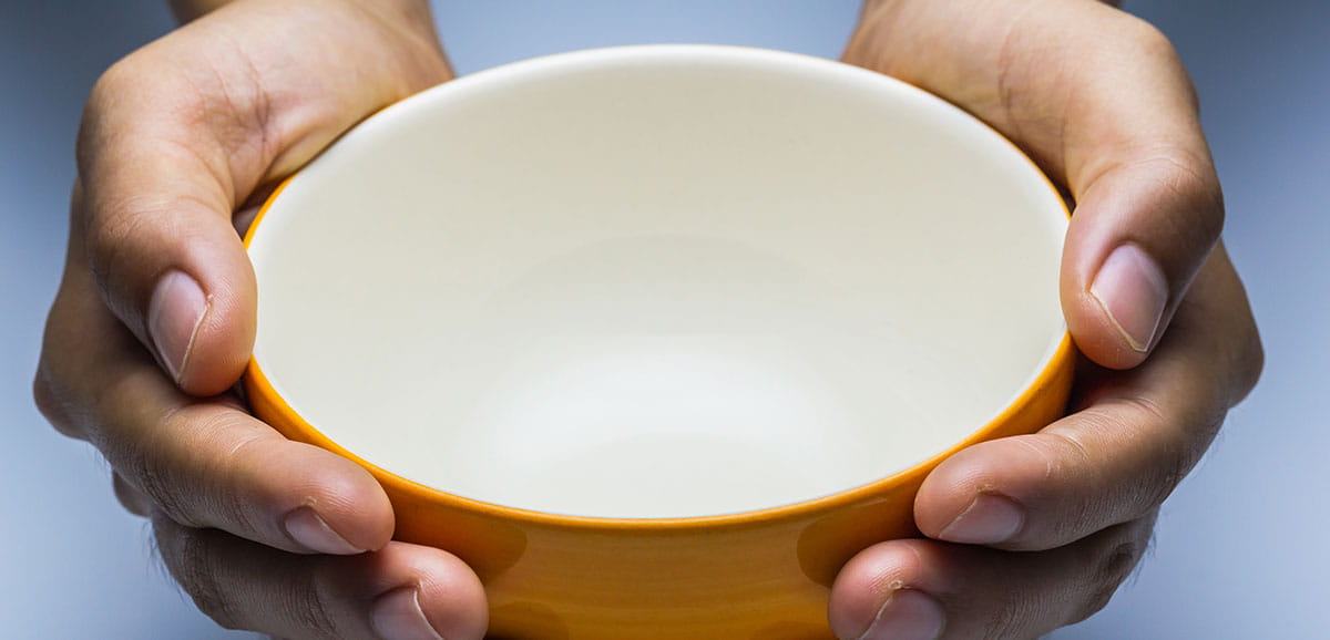 A close up on hands holding an empty bowl.