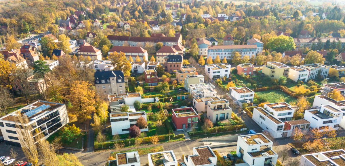 An aerial view of a town with tree lined streets and various buildings and homes.