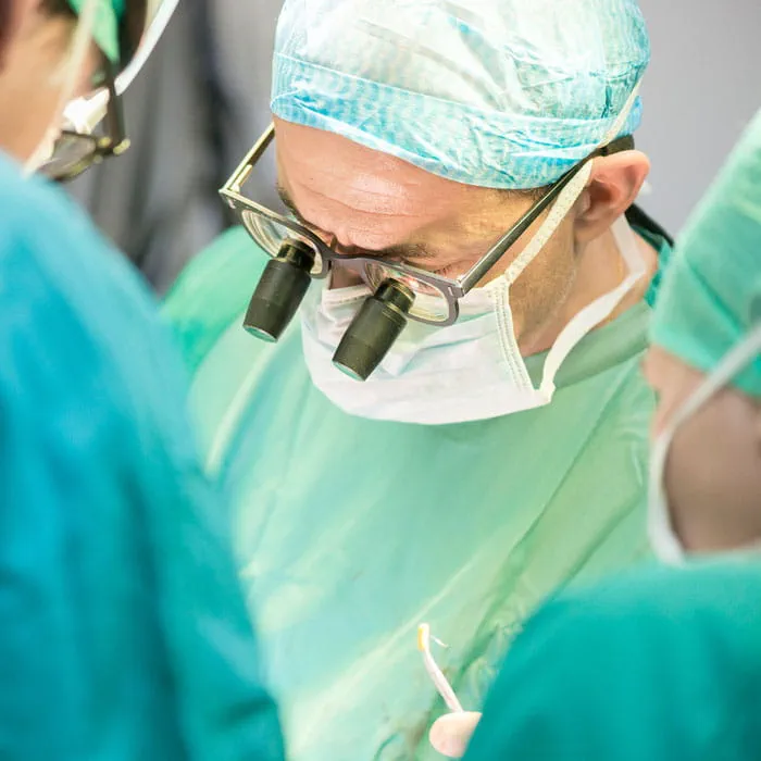 a cardiothoracic surgeon looks through a surgical loupe during an aortic surgery