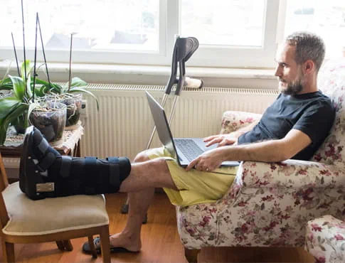 a man recovers at home after an Achilles tendon procedure