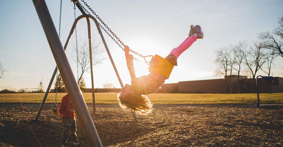 Girls swinging on a playground swing